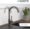 A kitchen faucet shown in a modern kitchen setting, with a plant in a concrete pot in the background. Produktbild-Vorschau