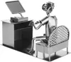 A metal figurine of a person sitting at a desk with a computer and a chair. Náhled obrázku produktu