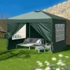 A green pop-up gazebo set up on a lawn with outdoor furniture inside. Podgląd zdjęcia produktu