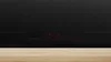 A close-up view of a black induction cooktop with red digital displays showing cooking settings. Náhľad obrázku produktu