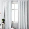A white curtain hanging in front of a window. Produktbild-Vorschau
