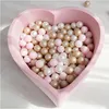 A heart-shaped ball pit filled with pink, pearl, and gold balls. Anteprima dell’immagine prodotto