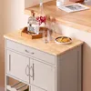 A kitchen cart with bottles, glasses, and chips on top. Voir les images du produit