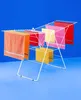 A white metal drying rack with colorful towels hanging on it, set against a bright blue background. Anteprima dell’immagine prodotto