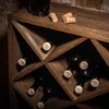 A close-up view of a wooden wine rack filled with dark wine bottles and corks on top. Voir les images du produit