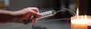 A hand holding a lighter to light a candle. Anteprima dell’immagine prodotto