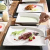 A table setting with plates of food, cutlery, and a candle. Produktbild-Vorschau