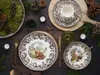 A table setting with plates, cutlery, and decorative elements like pine cones and greenery, suggesting a rustic or autumnal theme. Náhľad obrázku produktu