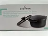 The image shows the packaging of a Crofton pot with a lid, along with a partial view of the product itself. Produktbild-Vorschau