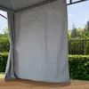 A grey curtain hangs in front of a gazebo, with a view of trees and a fence in the background. Produktbild-Vorschau