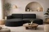 A modern living room with a dark fabric sectional sofa, a round wooden coffee table, and decorative elements. Produktbild-Vorschau