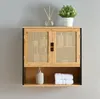A wall-mounted cabinet with woven doors, a shelf below, and decorative items on top. Podgląd zdjęcia produktu