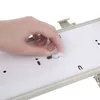 A hand is shown adjusting a small white plastic component on a white surface with gray trim. Podgląd zdjęcia produktu