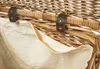 Close-up of a wicker basket with leather straps and a fabric liner. Podgląd zdjęcia produktu