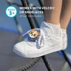 A close-up shot of a child's white sneaker with a cute corgi-shaped accessory attached to the shoelaces, with ropes in the foreground and background. Produktbild-Vorschau