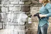 A person is cleaning a stone wall with a pressure washer and cleaning solution. Anteprima dell’immagine prodotto