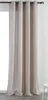 A close-up view of a beige curtain hanging from a curtain rod. Produktbild-Vorschau