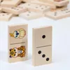 Two dominoes are shown in the foreground, with a pile of dominoes in the background. Produktbild-Vorschau