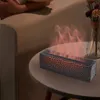 A humidifier with a flame effect sits on a side table next to a couch. A vase with dried flowers is in the background. Náhled obrázku produktu