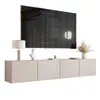 A modern TV stand with a large flat-screen TV mounted above it, decorated with a lamp, a bust, and dried flowers. Produktbild-Vorschau