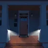 A front porch at night, illuminated by solar-powered wall lights mounted on the porch columns. Voir les images du produit