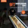 Two men playing shuffleboard in a dimly lit room with LED lighting on the table. Voir les images du produit