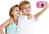 Two children taking a selfie with a pink digital camera. Produktbild-Vorschau