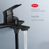 A close-up of a black matte shower faucet with water flowing out. Náhled obrázku produktu