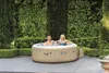 A couple relaxing in an inflatable hot tub in a garden setting. Produktbild-Vorschau