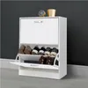 A white shoe cabinet with shoes on display, placed against a dark gray wall and light gray floor. Voir les images du produit