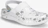 A white clog-style shoe with a silver floral pattern. Voir les images du produit