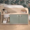 A child's bed with storage, featuring a desk and cabinets, set against a monkey-themed wallpaper. Produktbild-Vorschau