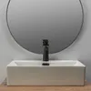 A white rectangular vessel sink with a black faucet in front of a round mirror. Náhľad obrázku produktu