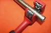 A close-up shot of a red pipe cutter gripping a metal pipe. Anteprima dell’immagine prodotto