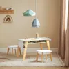 A child's activity table and chairs set in a room with neutral walls and curtains. Produktbild-Vorschau