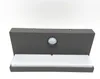 A dark gray outdoor light fixture with a motion sensor and a white light diffuser is shown against a white background. Anteprima dell’immagine prodotto
