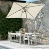 An outdoor patio scene with a rectangular umbrella shading a white dining table and chairs. The background features a stone wall and lush green ivy. Produktbild-Vorschau