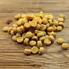 A pile of small, round, yellow dog treats on a wooden surface. Produktbild-Vorschau