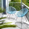 Two light blue chairs on a balcony with plants and trees in the background. Náhled obrázku produktu