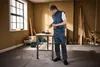 A man is using a cordless drill in a workshop setting. Produktbild-Vorschau