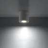 A concrete cylinder ceiling light is mounted on a gray ceiling, casting a downward light. Produktbild-Vorschau