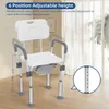 A white shower chair with armrests and backrest is shown in a room with sheer curtains in the background. The chair's height is adjustable. Náhled obrázku produktu