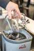 A person is using a glass washing device in a sink. Podgląd zdjęcia produktu
