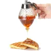 A hand holding a honey dispenser over waffles. Produktbild-Vorschau