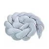 A braided pillow or bumper for a baby's crib, shown against a white background. Voir les images du produit