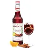 A bottle of Monin Sangria Mix syrup next to a glass of sangria and some garnishes. Produktbild-Vorschau