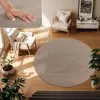 A circular rug in a living room setting with chairs and plants. Produktbild-Vorschau