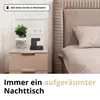 A bedside table with a plant and a wireless charging station next to a bed. Produktbild-Vorschau