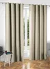 Two cream-colored curtains are hanging in front of a window, with a small white side table and a chair visible on the left. Produktbild-Vorschau