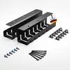 A set of black cable management trays, screws, and cable ties arranged on a white background. Produktbild-Vorschau